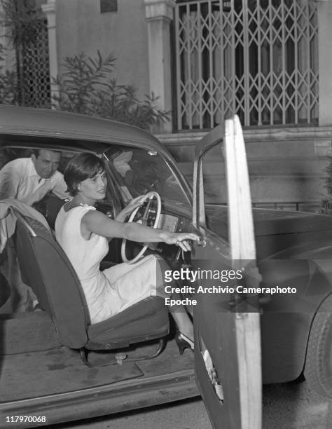 Italian actress Lucia Bose, wearing a sleeveless dress, portrayed while closing her car door, a man entering from the passenger side, Venice, Movie...