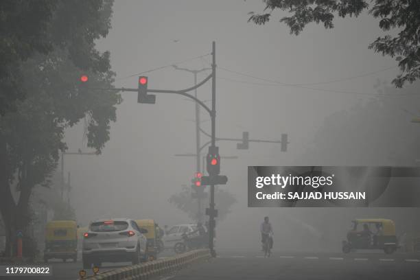 Motorists drive along a road under heavy smog conditions, in New Delhi on November 3, 2019. - India's capital New Delhi was enveloped in heavy, toxic...