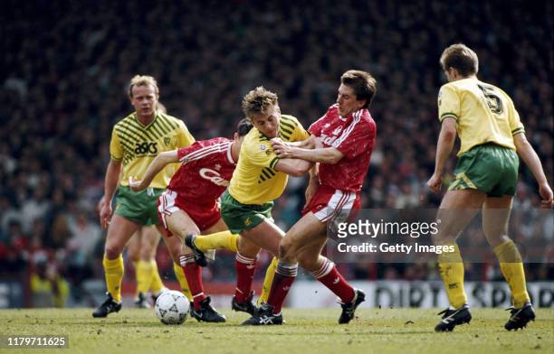 Liverpool player Peter Beardsley is challenged by Tim Sherwood of Norwich as Jeremy Goss of Norwich looks on during a First Division match at Anfield...