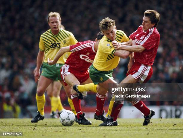 Liverpool player Peter Beardsley is challenged by Tim Sherwood of Norwich as Jeremy Goss of Norwich looks on during a First Division match at Anfield...