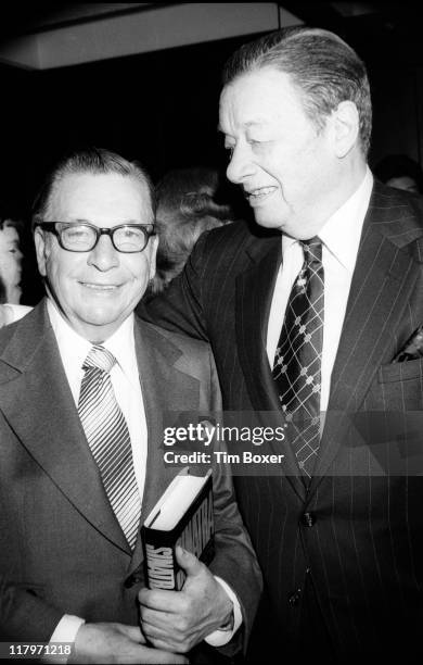 American journalist Earl Wilson , a copy of his book 'Sinatra: An Unauthorized Biography' under his arm, poses with restaurateur Toots Shor during...