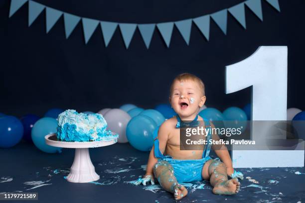 baby boy playing with a cake during cake smash birthday party - smash cake bildbanksfoton och bilder