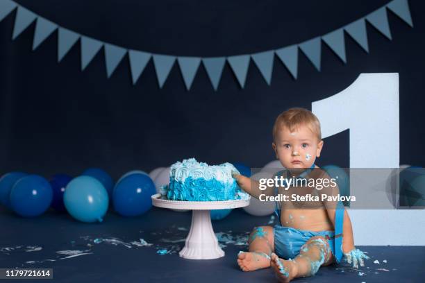 baby boy playing with a cake during cake smash birthday party - smash cake ストックフォトと画像