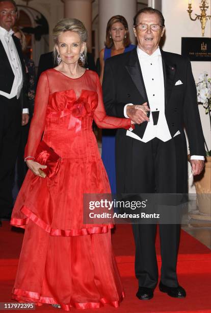 Sir Roger Moore and wife Kristina Tholstrup leave the Hotel Hermitage to attend a dinner at Opera terraces after the religious wedding ceremony of...