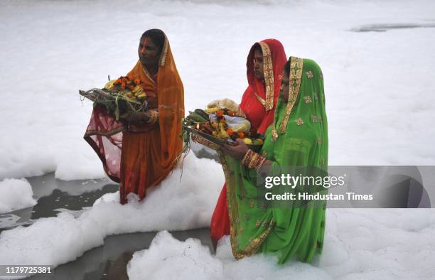 Devotees perform rituals in the polluted waters of Yamuna river at Kalindi Kunj on the occasion of Chhath Puja, on November 3, 2019 in Noida, India....