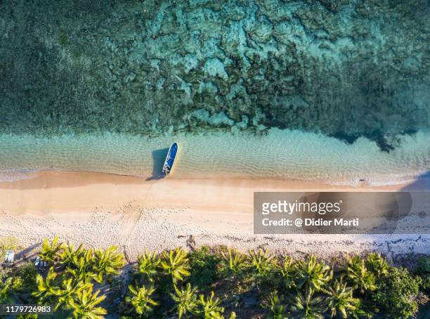 top down view of an idyllic island with a boat a coral reef in fiji in the south pacific ocean - fiji stockfoto's en -beelden