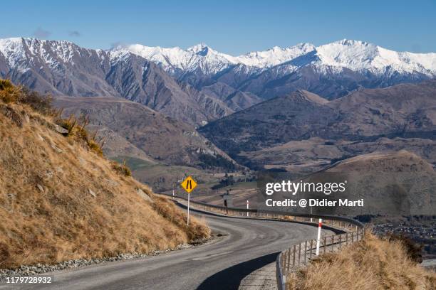 winding road in the remarkables mountain in queenstown, new zealand - new zealand otago road stock pictures, royalty-free photos & images