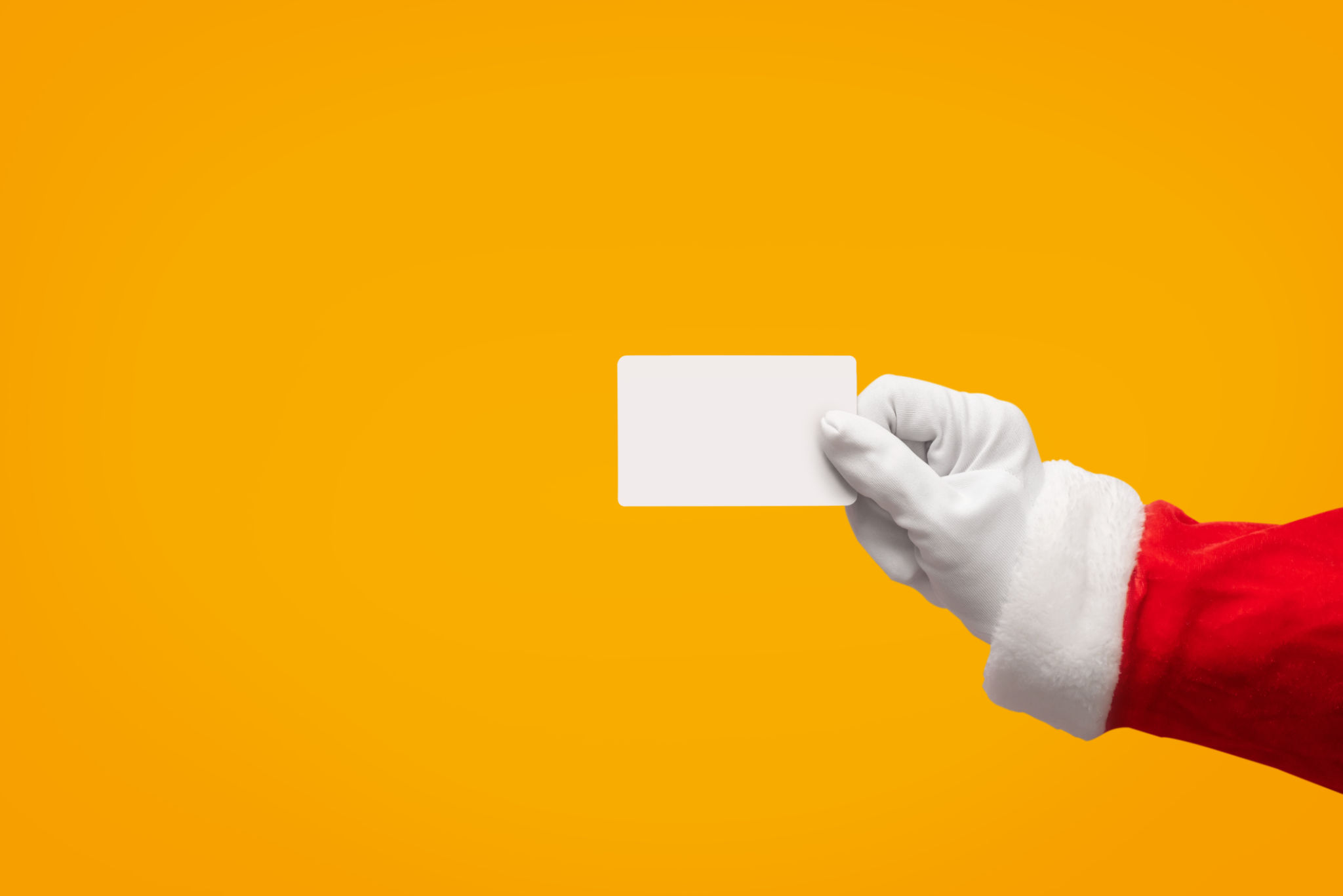 Santa Claus hand holding plastic credit card over isolated background. Santa Claus hand holding plastic credit card over isolated background.