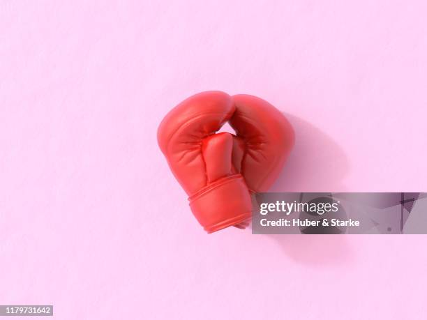 two boxing gloves making a shape of a heart - boxing glove coloured background stock pictures, royalty-free photos & images