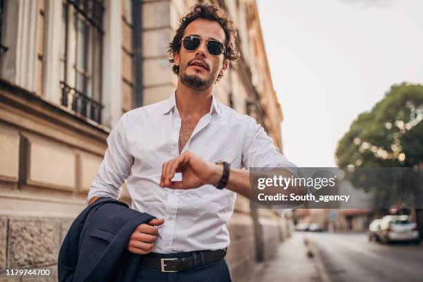 handsome gentleman checking the time - charming stock pictures, royalty-free photos & images