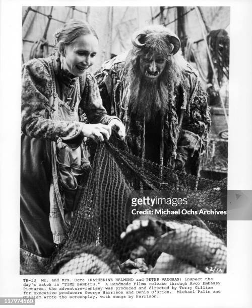 Katherine Helmond and Peter Vaughan inspect the day's catch in a scene from the film 'Time Bandits', 1981.