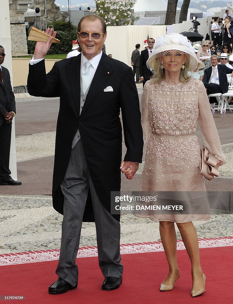 British actor Sir Roger Moore and his wife Kristina arrive for the