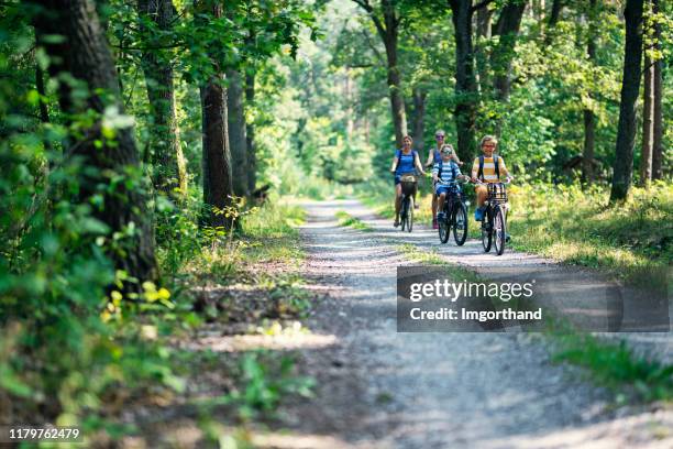 family enjoying a bike trip - two kids with cycle imagens e fotografias de stock