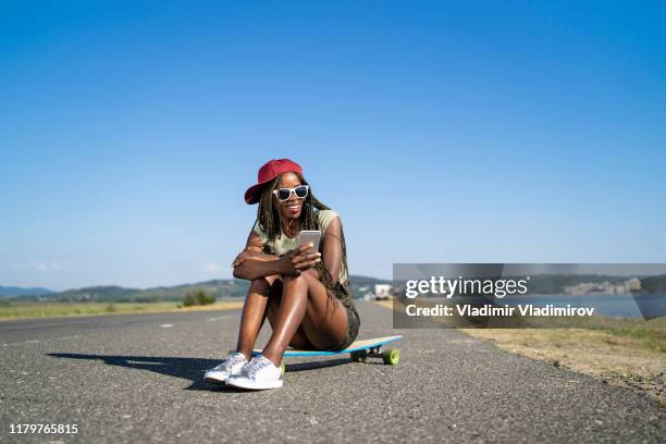 donna africana che si fa selfie sullo skateboard - funky foto e immagini stock