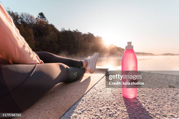 junge frau, die am frühen morgen yoga trainiert - drink bottle stock-fotos und bilder