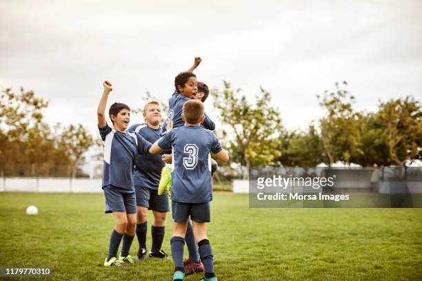 fußball-nationalmannschaft feiert erfolg nach spiel - jugendfußball stock-fotos und bilder