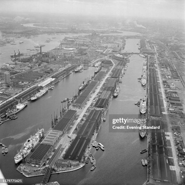 Aerial view of cargo ships loading and unloading freight at the Royal Docks located next to the River Thames in East London on 15th July 1970. The...