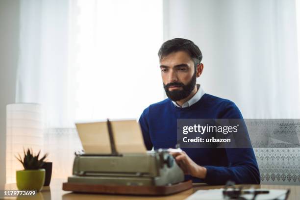 hipster-autor arbeitet an schreibmaschine - schreibmaschine stock-fotos und bilder