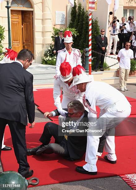 Prince Laurent of Belgium is helped to his feet after falling over as he attends the religious ceremony of the Royal Wedding of Prince Albert II of...