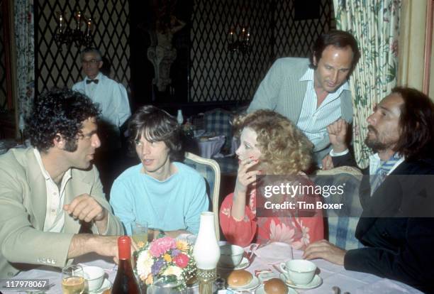 Seated from left, American actor Elliott Gould, British singer Mick Jagger, South African actress and singer Genevieve Waite, and her husband,...