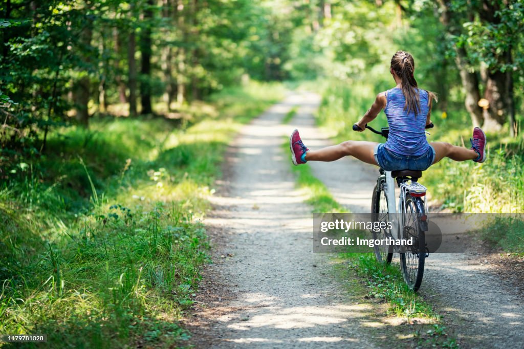 Teenage girl enjoying riding a bike.