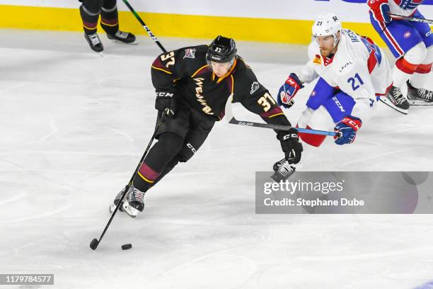 Markus Hannikainen of the Cleveland Monsters takes control of the puck while Dale Weise of the Laval Rocket chases him at Place Bell on October 4,...