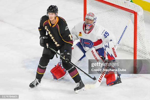 Charlie Lindgren of the Laval Rocket making sure he sees the play while Paul Bittner of the Cleveland Monsters tries to block his view at Place Bell...