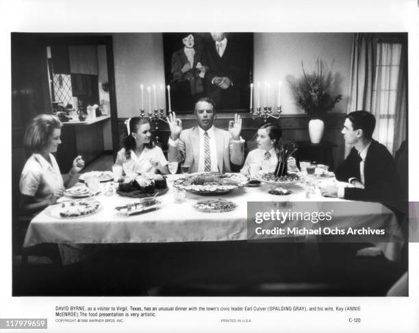 Annie McEnroe, Spalding Gray, and David Byrne sit around the dinner table in a scene from the film 'True Stories', 1986.