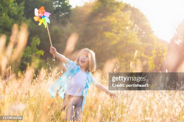 glückliches kind mit zahnrad-spielzeug - paper windmill stock-fotos und bilder