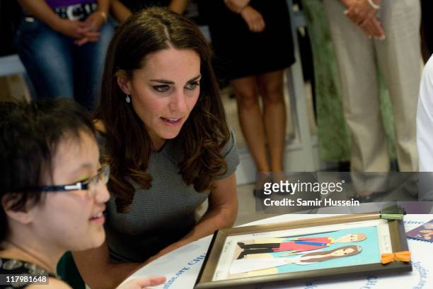 Catherine, Duchess of Cambridge meets a young girl as she visits a children's cancer ward at Sainte-Justine University Hospital on day 3 of the Royal...