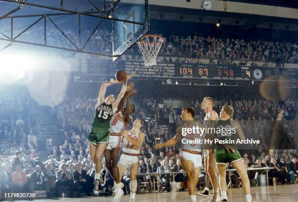 Tom Heinsohn of the Boston Celtics goes for the shot as Bob Hopkins of the Syracuse Nationals defends during an NBA game on November 3, 1957 at...