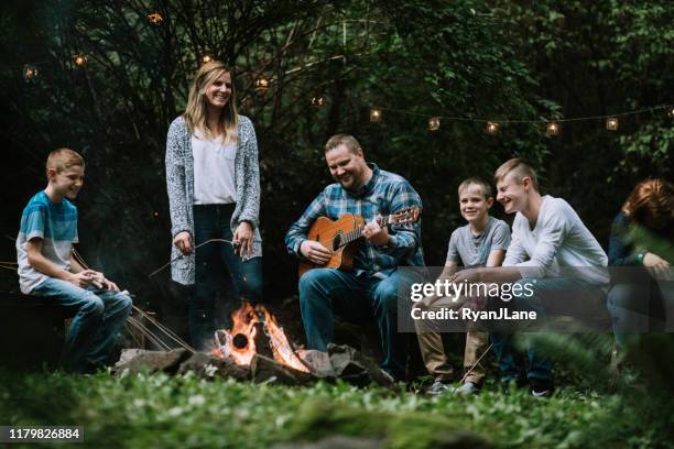 family fun around a campfire with music and food - musical instrument stock pictures, royalty-free photos & images