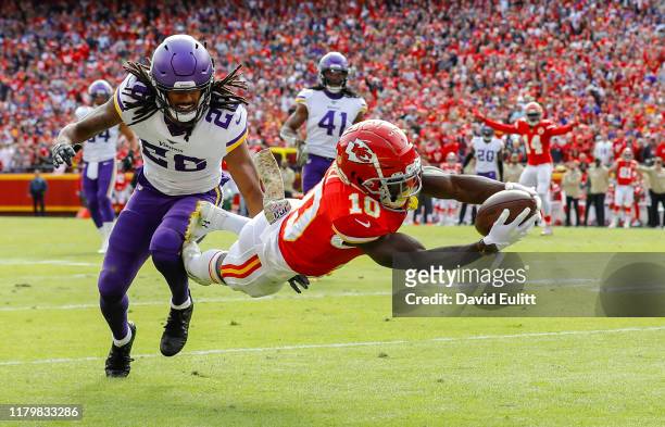 Tyreek Hill of the Kansas City Chiefs leaps to the goal line on a 40-yard touchdown pass behind the defense of Trae Waynes of the Minnesota Vikings...