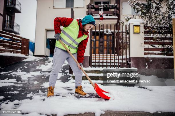 mann mit schneeschaufel - entfernen stock-fotos und bilder