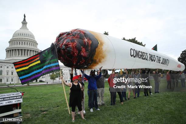 Members of DC Marijuana Justice hold up a large simulated joint during rally to urge Congress to pass meaningful cannabis reform legislation, on...