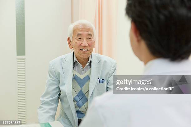 senior patient talking to doctor, kanagawa prefecture, honshu, japan - medical examination room stock pictures, royalty-free photos & images