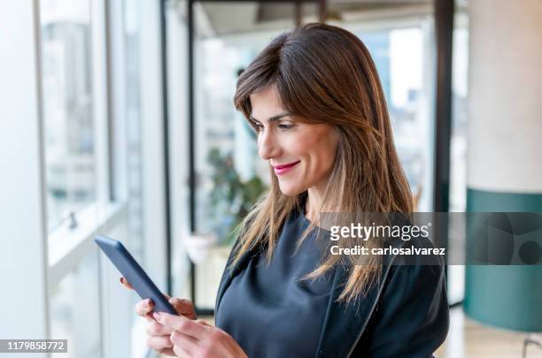 donna che usa il suo smartphone - chief administration office foto e immagini stock