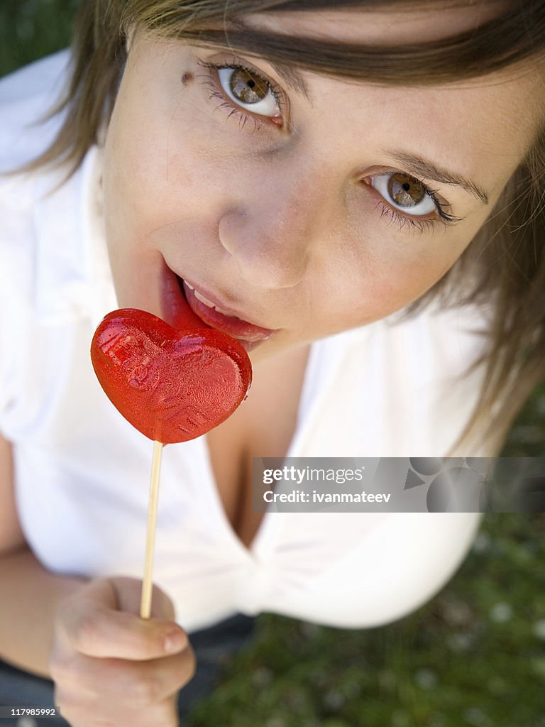 Woman with heart-shaped lollipop