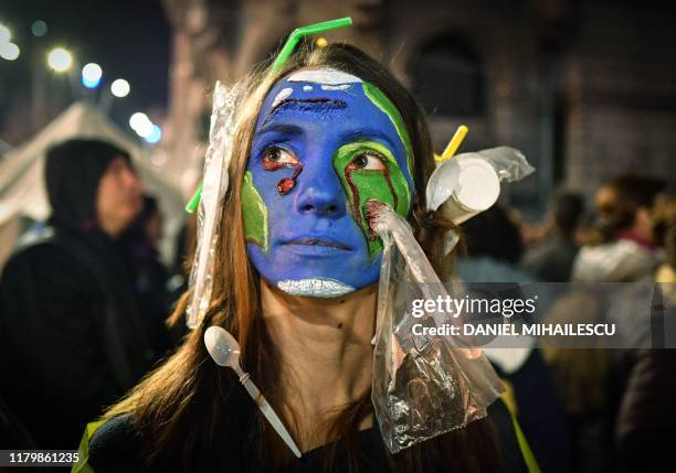 Woman wearing plastic on her hair and with her face painted with earth colors demonstrates during a protest against illegal logging in the forests of...