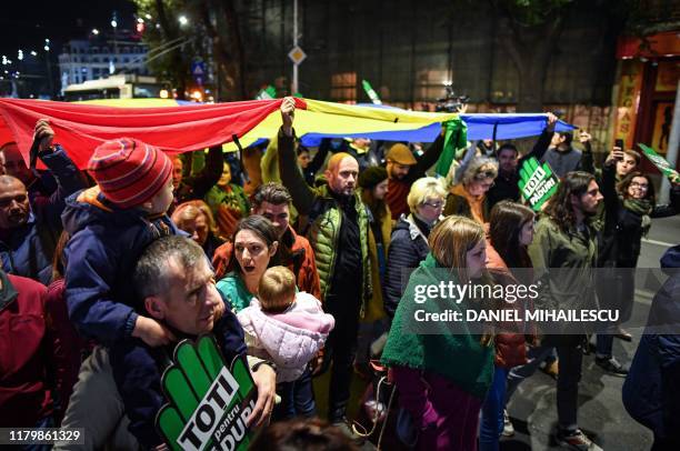 People demonstrate holding a Romanian flag during a protest against illegal logging in the forests of Romania gathering aroung 4,000 people downtown...