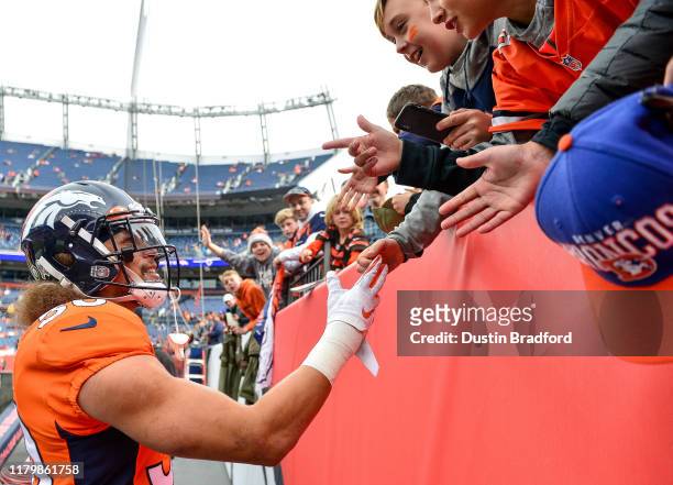 Phillip Lindsay of the Denver Broncos has a word with young fans during warm ups before a game against the Cleveland Browns at Empower Field at Mile...