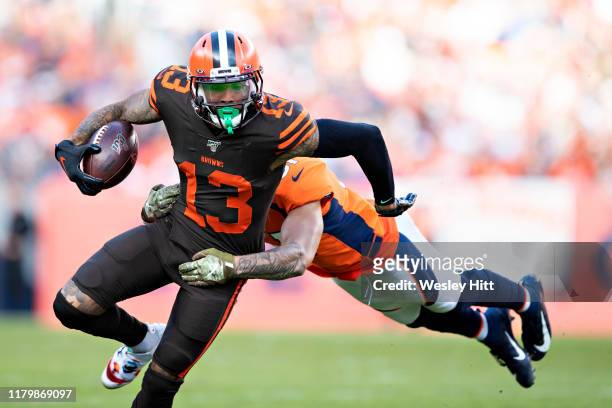 Odell Beckham Jr. #13 of the Cleveland Browns runs the ball after catching a pass and is tackled by Todd Davis of the Denver Broncos during the first...