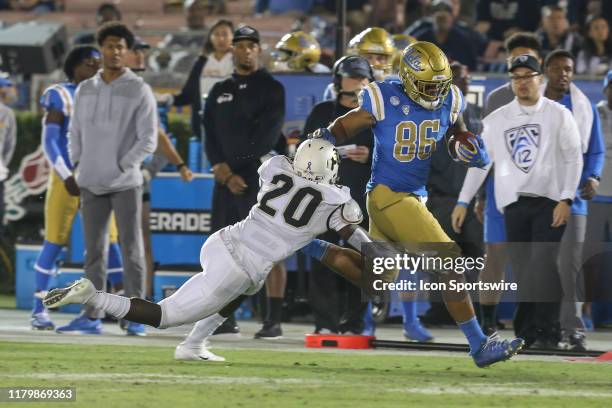 Bruins tight end Devin Asiasi stiff arms Colorado Buffaloes linebacker Davion Taylor during the college football game between the Colorado Buffaloes...