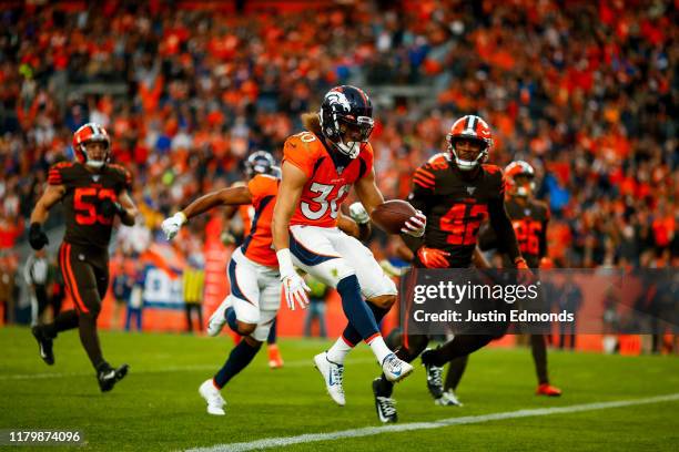 Running back Phillip Lindsay of the Denver Broncos scores a touchdown as safety Morgan Burnett of the Cleveland Browns looks on during the third...