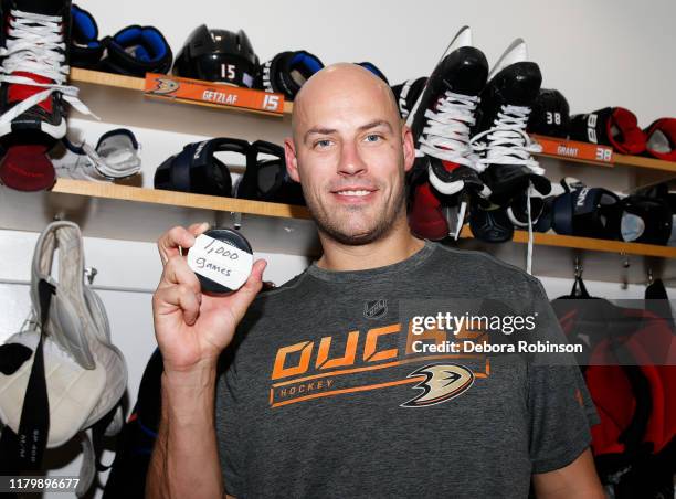 Ryan Getzlaf of the Anaheim Ducks poses with a puck in the locker room for his 1,000th NHL career game after a 3-2 overtime loss to the Chicago...