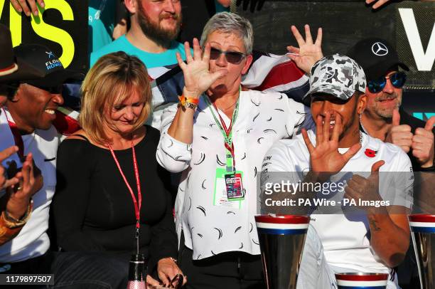 Mercedes driver Lewis Hamilton celebrates winning his sixth world championship with his mum Carmen Larbalestier and his dad Anthony after the United...