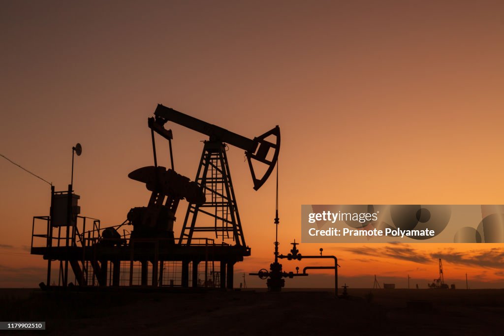 Oil pumps at sunset,  industrial oil pumps equipment.