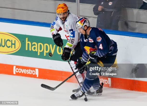 Dominik Uher of Fischtown Pinguins Bremerhaven and Blake Parlett of EHC Red Bull Muenchen battle for the puck during the DEL match between EHC Red...