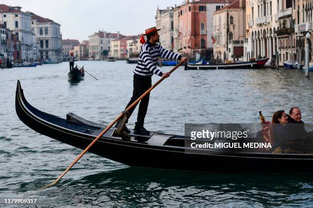 Gondolier ferries tourists along the Grand Canal in Venice on November 4, 2019.