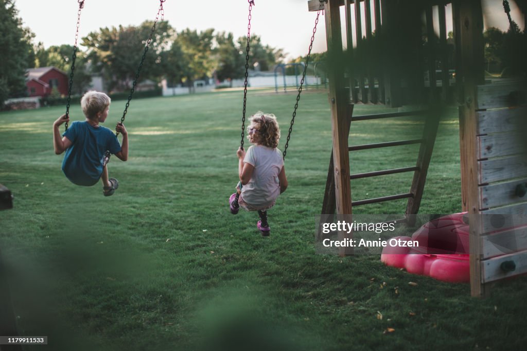 Back view of children swinging